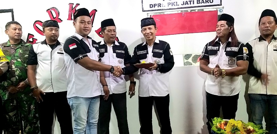 Ketua DPC Forkabi Kecamatan Cinere, H. Samali. H.S menerima potongan nasi tumpeng yang diberikan Ketua DPRt Forkabi Pangkalam Jati baru, Olan Bagol.